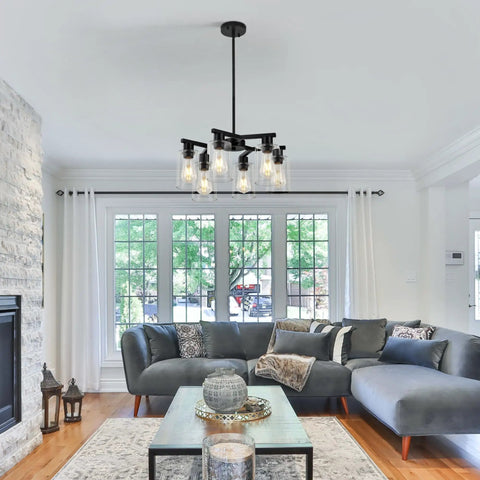 Six Light Matte Black Modern Farmhouse Chandelier With Clear Glass Shades adjustable hanging in a stylish living room setting.