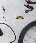 Folding Hex Key Set With Metric And SAE Allen Wrenches, Heat Treated S2 Finish, shown next to bicycle tools on concrete