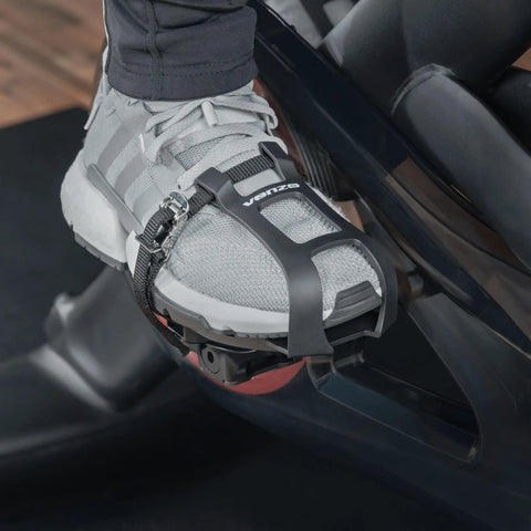 Toe Clip Cage Adapters For Look Delta Pedals convert Peloton pedals to toe clip straps, shown with sneaker on spin bike pedal.