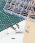 Image of 100Pcs Stainless Steel Extension Spring Kit In 25 Sizes, 0.3mm To 1.2mm Wire Diameters, with storage box on a cutting mat.