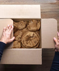 Top Tier Honeycomb Packing Paper Bubble Wrap Alternative For Moving Supplies Stretchy Kraft Cushion Roll in a box with hands.