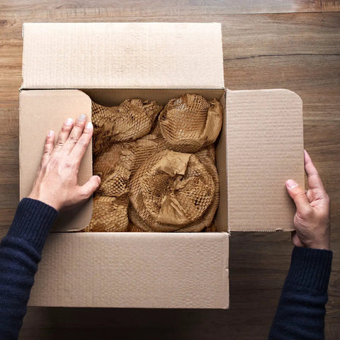 Top Tier Honeycomb Packing Paper Bubble Wrap Alternative For Moving Supplies Stretchy Kraft Cushion Roll in a box with hands.