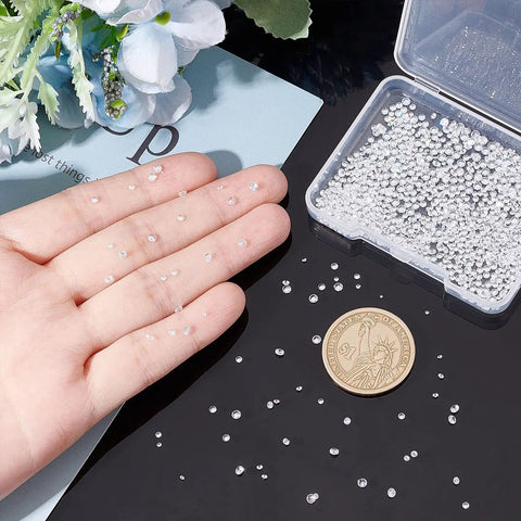Hand holding Loose CZ Diamond Stones Kit 2400 Clear Cubic Zirconia Rhinestones In 8 Sizes From 0.8mm To 2.5mm Glass