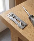 Set Of Six Heavy Duty Iron Sectional Couch Connectors For Modular Sofas With Long Travel Hinge And Antislip Finish on wooden surface with screwdriver.