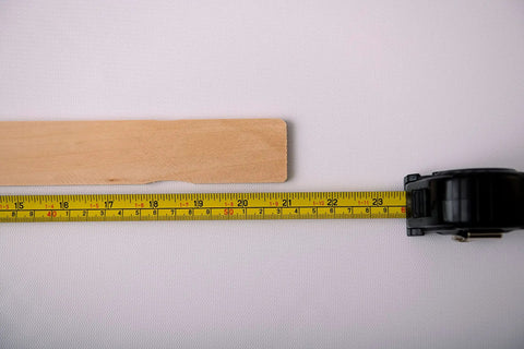 American-Made Basswood Paint Stir Sticks 21 Inch Bulk 250 Count with tape measure showing 21-inch length