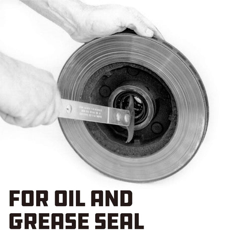 Powerbuilt seal puller in use to remove an oil/grease seal from a round bearing housing; gloved hands.