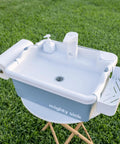 Real Deal Portable Sink With Genuine Running Water For Camping Van Life Outdoor Vendor Booths And Home Remodels Zero Hassle Setup Instant Sink Action Smooth On The Fly Hygiene Station on grassy surface with faucet and paper towel holder.