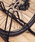 Close-up of Heavy Duty Bicycle Floor Parking Rack Stand For Mountain And Road Bikes Indoor Home Garage Storage with tire grooves.