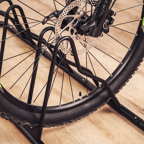 Close-up of Heavy Duty Bicycle Floor Parking Rack Stand For Mountain And Road Bikes Indoor Home Garage Storage with tire grooves.