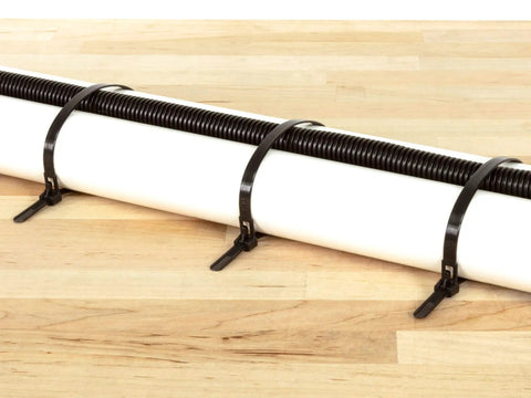 Heavy Duty 12 Inch Black Releasable Cable Ties 100 Pack Nylon 66 Zip Ties securing a white pipe against a wooden surface.