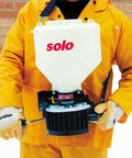 20 Pound Capacity Portable Chest Mount Spreader With Cross Shoulder Strap in use by person in orange suit outdoors
