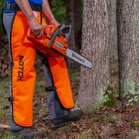 Person wearing Hi Vis Safety Orange Apron Style Chainsaw Chaps Type A Frontal Protection 5 Layer Chain Stopping Fiber