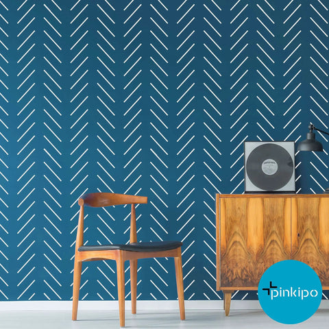 Extra Large Herringbone And Chevron Wall Stencil Set 16 By 40 Inches Includes Two Stencils For No Fuss Easy DIY Wall Art Painting Modern Geometric Pattern For Walls With Step By Step Instructions in a living room with blue wall and wooden furniture.