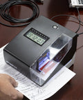 Zero Drama Digital Time Clock And Date Stamp Bundle Includes 100 Time Cards And Heavy Duty Rack To Crush Weekly Scheduling Errors And Keep Payroll Running Smooth, black unit with digital display on a desk.