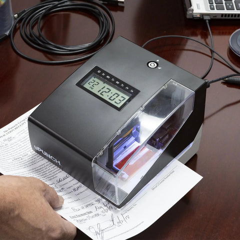 Zero Drama Digital Time Clock And Date Stamp Bundle Includes 100 Time Cards And Heavy Duty Rack To Crush Weekly Scheduling Errors And Keep Payroll Running Smooth, black unit with digital display on a desk.