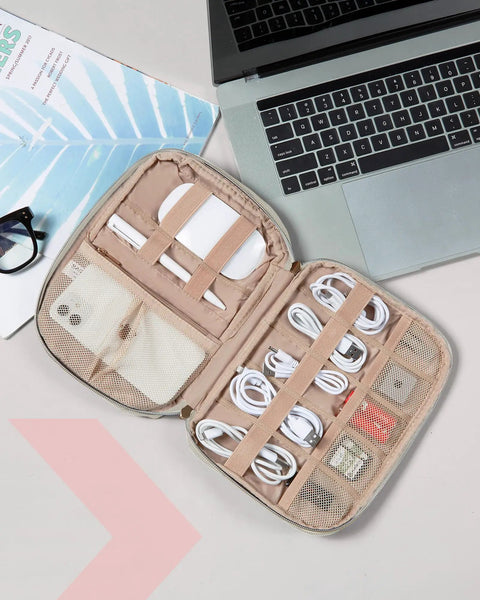 Open view of beige travel electronics organizer case for women with cords, phone, and SD cards beside a laptop, ultra compact size.