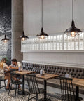 Black Pendant Light Set 3 Pack, Industrial Farmhouse Pendant Lighting over rustic dining tables in a modern cafe setting, vintage style.