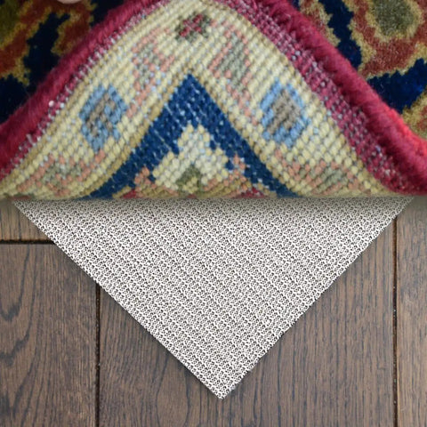 No Slip Full Size Mattress Gripper And Rug Pad Keeps Mattress In Place And Rug From Sliding All Night Long Non Adhesive PVC Foam Anti Slip Pad For Bedroom And Living Room shown under a colorful rug on wooden floor