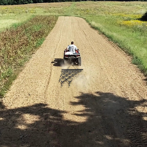Chain Drag Harrow For ATV And UTV, 5 Foot Wide By 4.5 Foot Long With Half Inch Tines, towed by ATV on dirt road