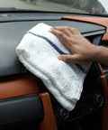 Value Pack Of 36 Absorbent 16x19 Inch Terry Cloth Cleaning Rags For Home And Business being used to clean a car dashboard