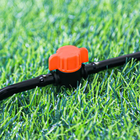 Close-up of 20 Pack One Quarter Inch Drip Irrigation Valve Fittings With In Line Shut Off Valves Barbed Connectors in grass