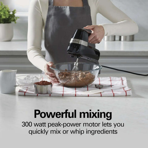 Slick Electric Hand Mixer Packing Six Speeds Plus A Dedicated Stir Button To Dodge Splatter While Whipping Up Thick Dough Or Fluffy Batter Plus Dual Beaters And Heavy Duty Hook Attachments in use mixing chocolate batter.