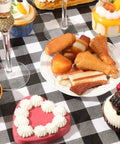 Outdoor Picnic Table Cover Set With Bench Covers 3 Piece Waterproof Vinyl Fitted Tablecloth Black And White Checkered Design with assorted desserts on a table.