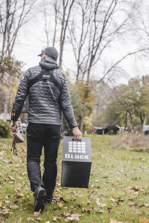 Person carrying archery target with "BLOCK" logo, illustrating 3D Archery Target 48 Inch Tall With Replaceable Insert For Long Life