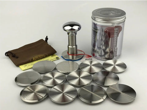 58.35 Mm Espresso Coffee Tamper Kit With Stainless Steel Base And Silver Mirrored Aluminum Handle Comes With Hella Tough Silicone Mat Plus Travel Pouch shown with various metal discs.