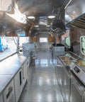 Interior view of Fully Equipped Compact Concession Food Trailer Mobile Kitchen with stainless steel counters and appliances.