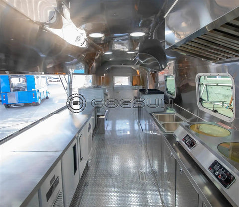 Interior view of Fully Equipped Compact Concession Food Trailer Mobile Kitchen with stainless steel counters and appliances.