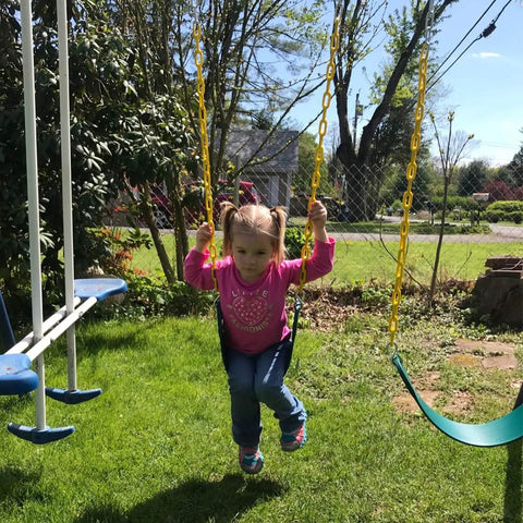 Child playing on 2 Pack Heavy Duty Kids Swing Seat Set With 66 Inch Chain Plastic Coated For Outdoor Playground Replacement Includes Safety Snap Hooks And EVA Seats That Supports Up To 250 Lbs Backyard Ready