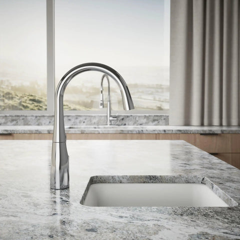 Polished chrome single handle kitchen bar faucet for prep sink with single hole installation on granite countertop.