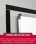 Black Adhesive Hook And Loop Tape Roll Five Feet By Three Quarters Inch Cut To Length Strips securing whiteboard on wall.