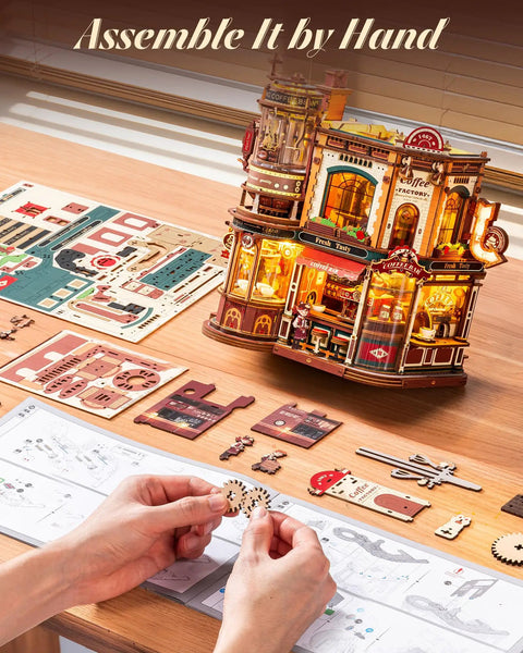 Hands assembling Dream Coffee Factory Mechanical 3D Wooden Puzzle Kit With Moving LED Lights For Adults on desk