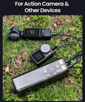 Drone Power Station Portable Charger 100Wh 27000mAh on grass charging action cameras via USB, showcasing versatility.