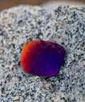 Apex Polarized PRO Replacement Lenses For Electric Stacker Sunglasses In Cool Violet Tint resting on a textured granite rock.