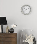 Room with 10 Inch Wall Clock Safe With Hidden Shelf Storage, battery operated analog timepiece, next to a lamp and chair.