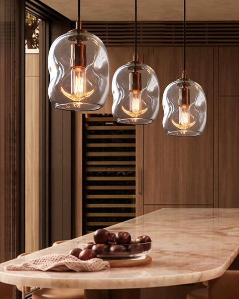 Dope Clear Art Glass Pendant Lights 2 Pack For Kitchen Island And Dining Room Table Modern Organic Globe Ceiling Fixture with Sleek Brass Gold Hardware above marble countertop.