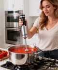 Person using Powerful 1200W Immersion Hand Blender With 5 In 1 Attachments Including Whisk Chopper Milk Frother Mixing Cup And Storage Rack For Smoothies Soups Baby Food And Purees A True Kitchen Game Changer Emulsifier in kitchen