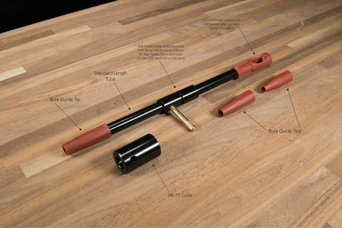 Universal Bore Guide With Three Muzzle Guides for no fuss cleaning rod alignment, showing components on wooden surface.