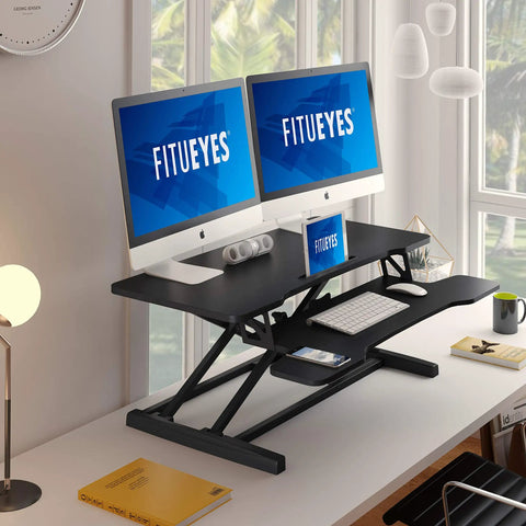 Height Adjustable Standing Desk Converter 36 Inch Wide Sit To Stand Riser For Laptops And Dual Monitors Black Tabletop Workstation Elevates Up To 19.8 Inches For Any Height Boss Level Ergonomic Setup SD309101WB holding dual monitors in office setting