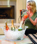 Acrylic Oval Party Tub With Handles For Chilling Drinks Indoor Outdoor Bar Use Crystal Clear Beverage Cooler Ice Tub For Wine Beer And Soda Easy Carrying Drink Station on a table with drinks and ice, woman holding a drink.