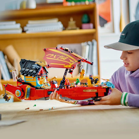 Child playing with Ninjago Destiny's Bounty Race Against Time 71797 Airship Battle Set With 6 Minifigures, 2 Dragons indoors