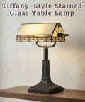 Tiffany Style Bankers Lamp With Stained Glass Shade For A Dope Desk Setup on wooden table, vintage mission design, warm glow