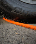 High Performance Hybrid Air Compressor Hose 3 8 By 10 Ft kink resistant under a tire on asphalt.