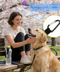 Woman with a dog sitting on a bench, Durable Silicone Water Bottle Holder With Carabiner Clip and Key Ring attached to the bottle.