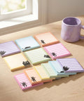 Black Cat Sticky Notes 3x3 Set For Back To School And Office displayed on a desk with colorful cat designs and a mug