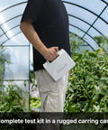 Person holding AI209 Value Series PH20 Waterproof pH Tester Kit case in a greenhouse