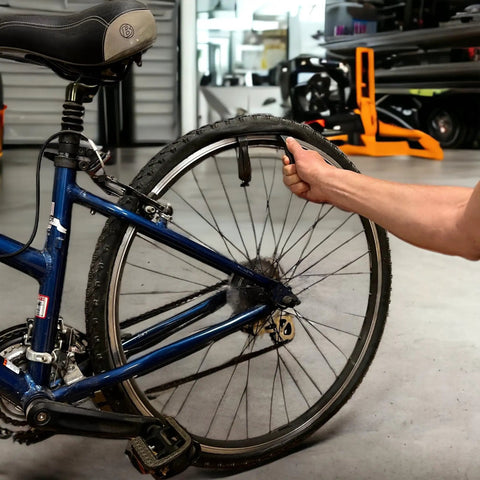 Using Interlocking Four-Piece Tire Lever Set For Road, MTB, Gravel And BMX Bikes to remove tire on floor bicycle.